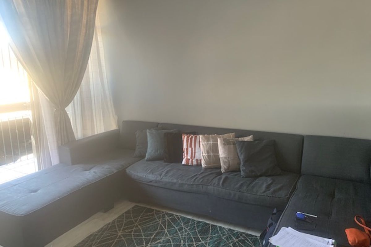 A living room area featuring a large sliding glass door providing natural light and access to an outdoor space.