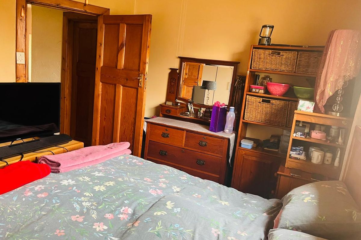 A bedroom featuring wooden door frames and doors, providing a traditional aesthetic with standard bedroom layout.