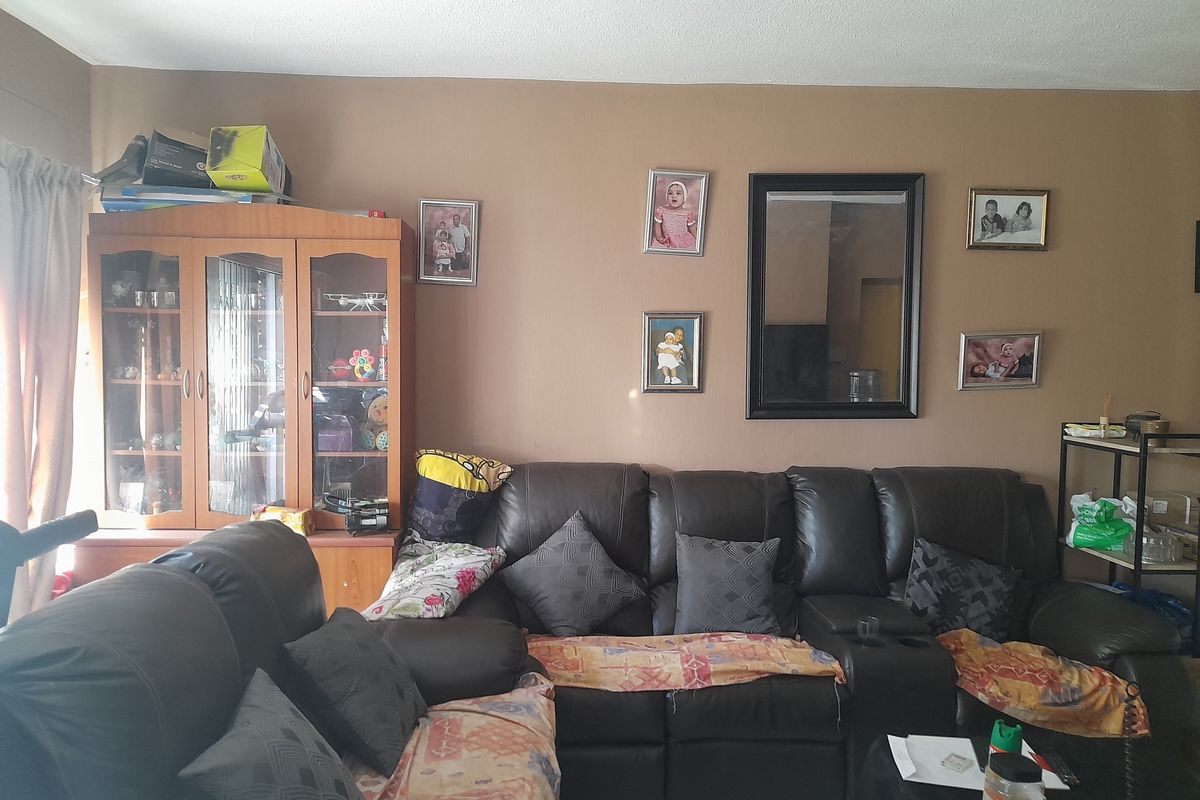A living room area featuring tiled flooring and neutral wall tones, providing a functional space for relaxation.