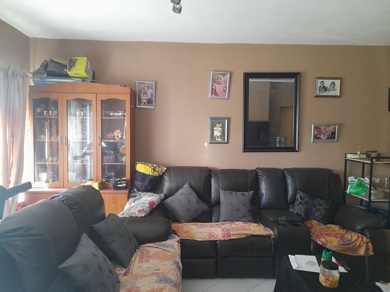 A living room area featuring tiled flooring and neutral wall tones, providing a functional space for relaxation.