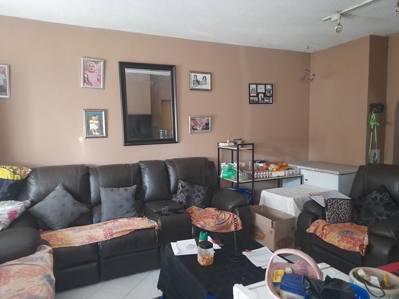 A living room area featuring tiled flooring and neutral wall paint, providing a functional space for relaxation.