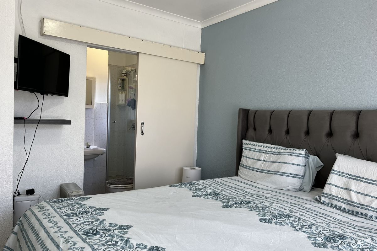 A bedroom featuring a sliding door leading to an en-suite bathroom, with a neutral color palette and built-in door hardware.