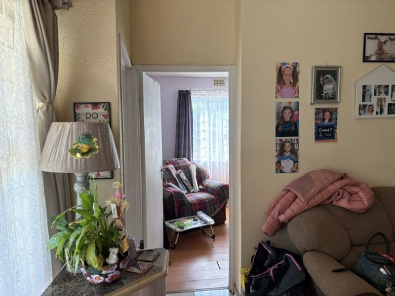 A view from a living area looking through a doorway into an adjacent room with natural light from a window.