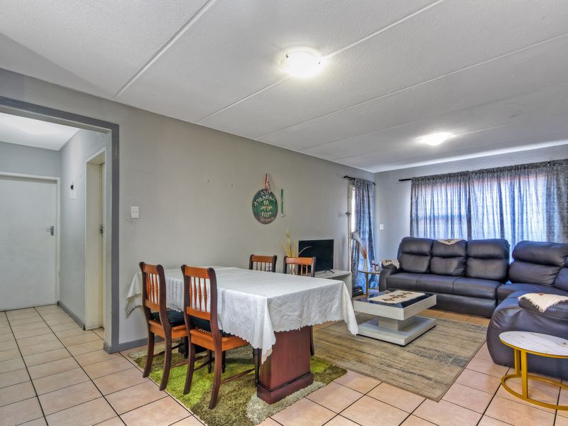 Open-plan living and dining area featuring tiled flooring and neutral wall finishes, providing a functional space for daily living and entertaining.