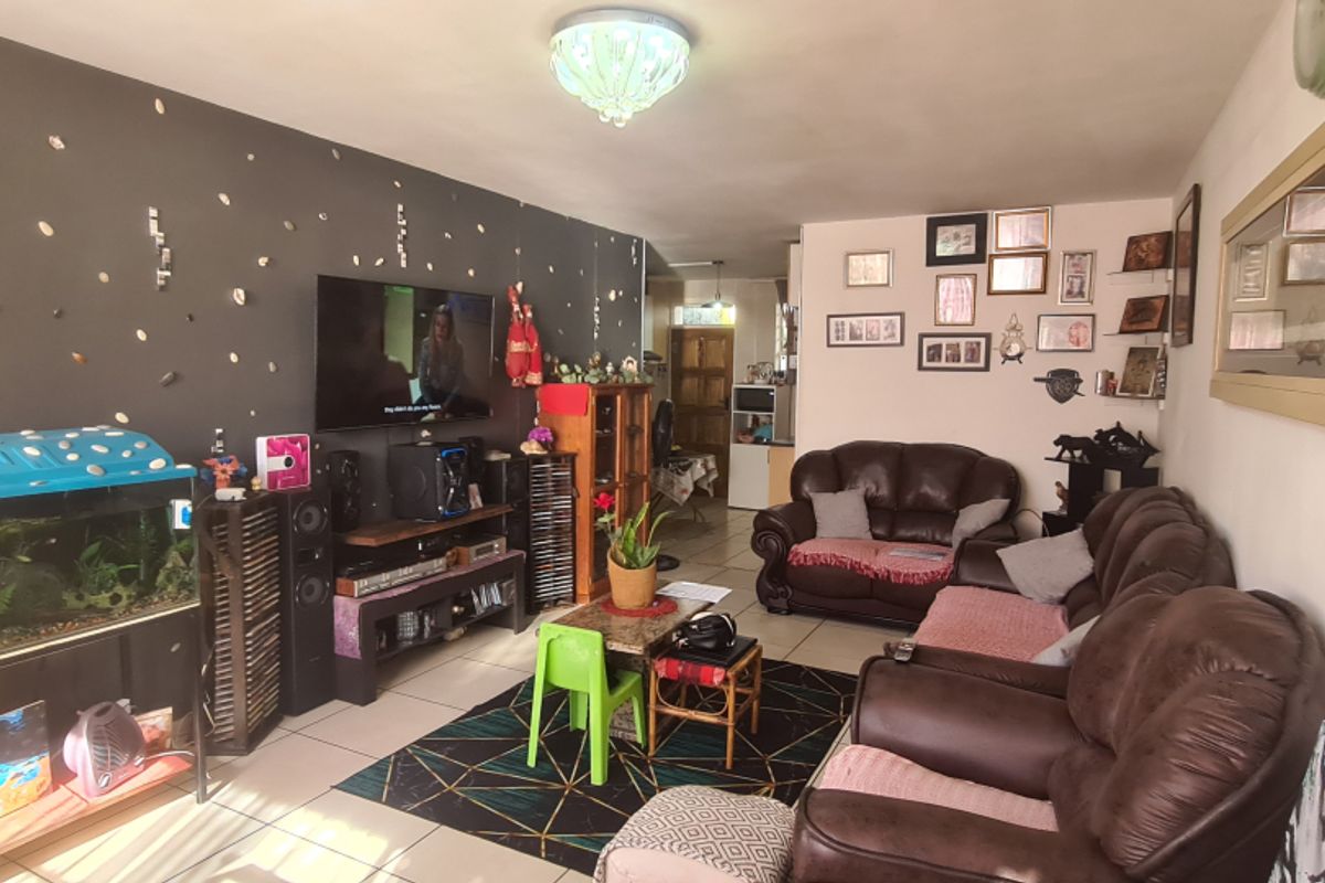 A living room featuring tiled flooring and a dark accent wall, providing a functional space for relaxation and entertainment.