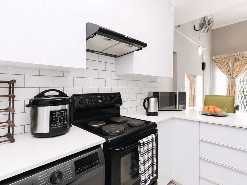 Modern kitchen featuring white cabinetry, subway tile backsplash, and integrated appliances, offering a clean and functional cooking space.