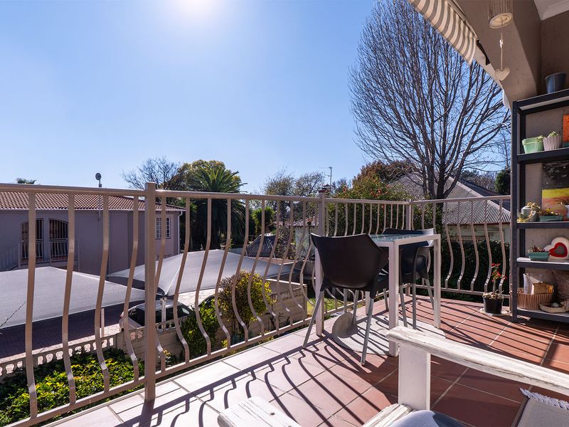 A sunny balcony featuring tiled flooring and a secure metal balustrade, offering an open outdoor space for relaxation.