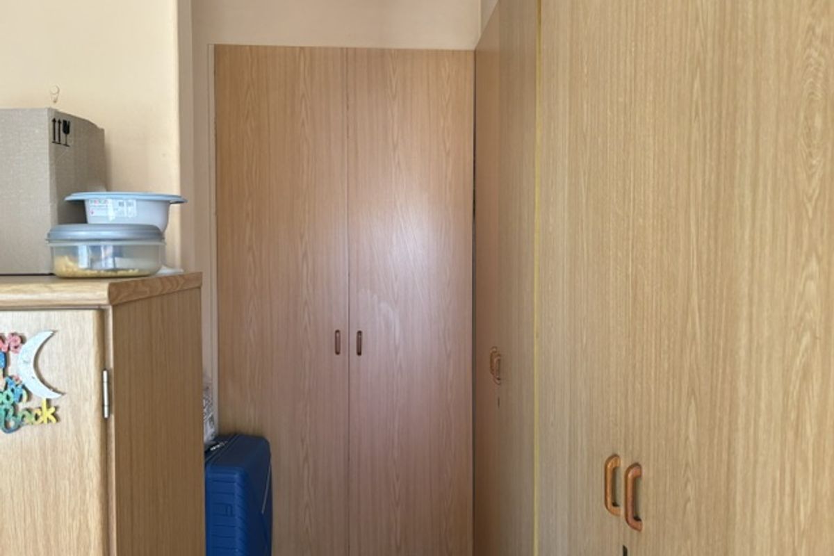 A bedroom featuring extensive built-in wooden cabinetry providing ample storage space.