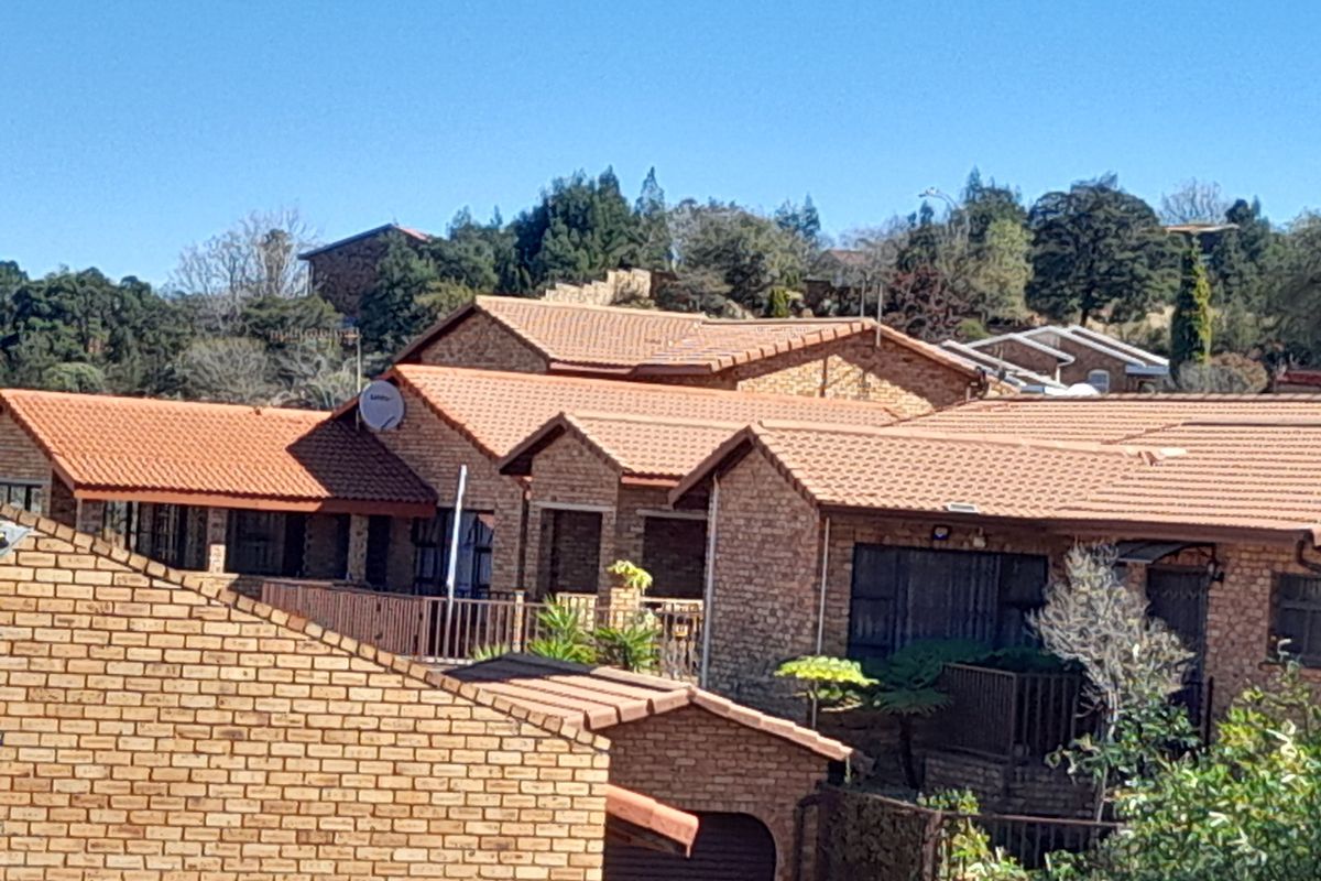An elevated view of a cluster property complex featuring face-brick facades and terracotta tiled roofs.