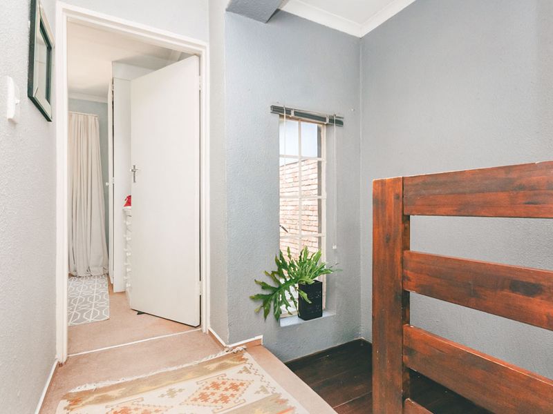 A functional hallway area featuring neutral wall finishes, coving, and access to an adjoining room through a standard internal door.
