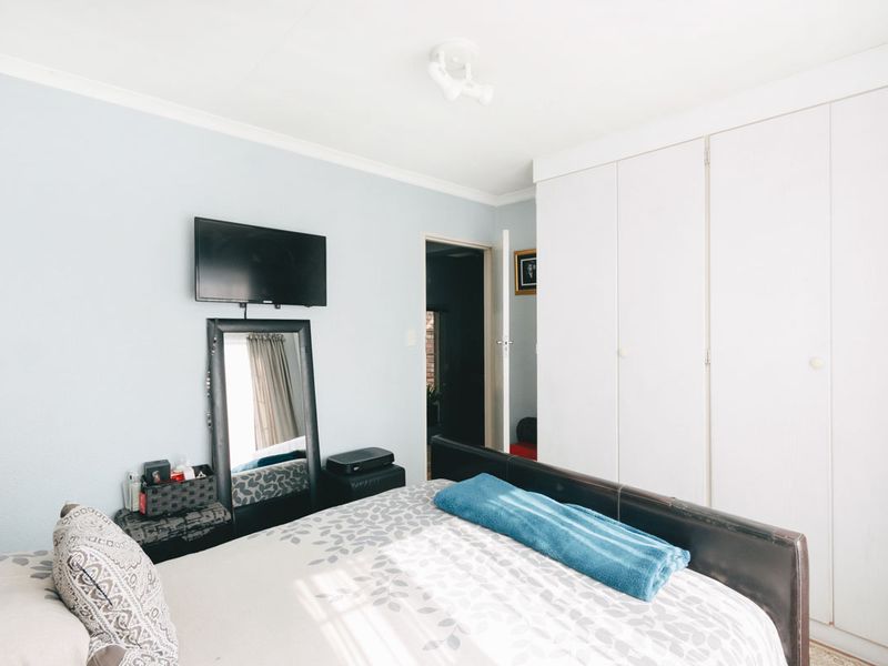 A functional bedroom featuring built-in cupboards and neutral wall finishes, providing a practical and comfortable living space.