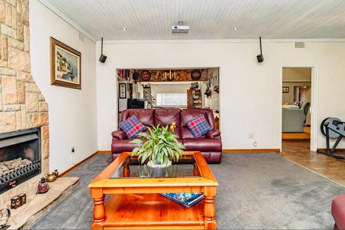 Spacious living room featuring a prominent stone fireplace, tongue and groove ceiling, and integrated audio-visual infrastructure.