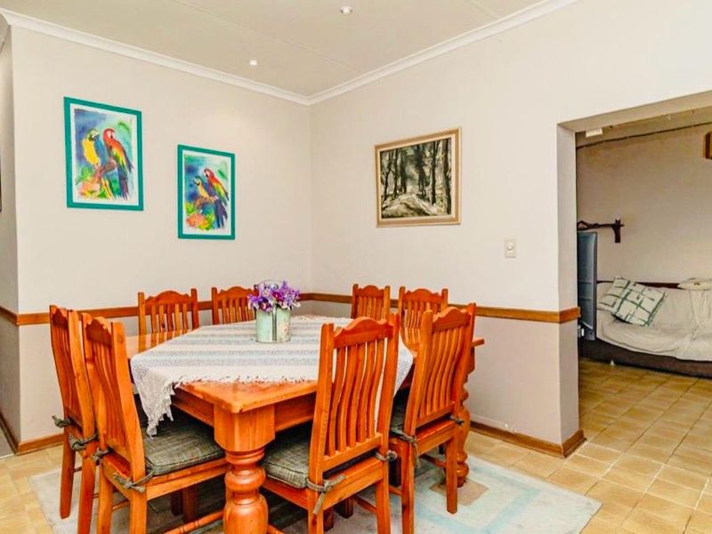 Dining area featuring tiled flooring, coved ceilings, and recessed lighting, with an open-plan transition into the adjacent living space.