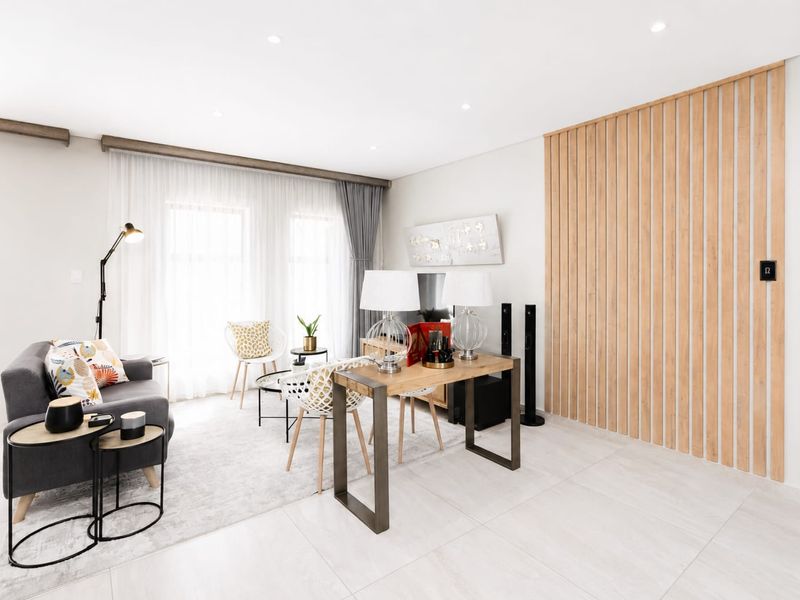 Modern living room featuring light-toned tiled flooring, recessed downlighting, and a contemporary timber slat feature wall.