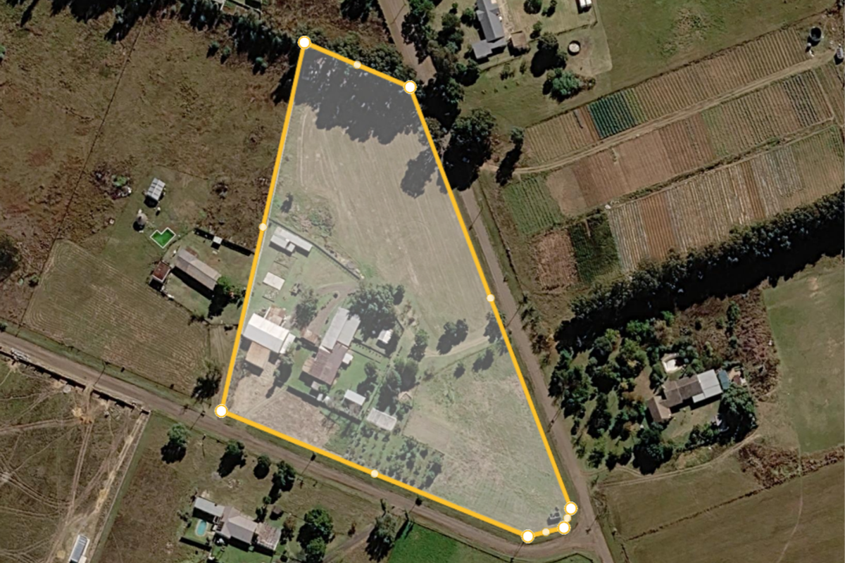 Aerial view of the small holding property showing the land boundary, existing structures, and surrounding agricultural landscape.