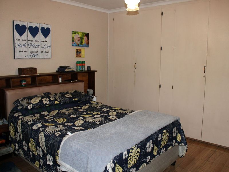 A functional bedroom featuring built-in cupboards and tiled flooring, offering a neutral base for personalization.