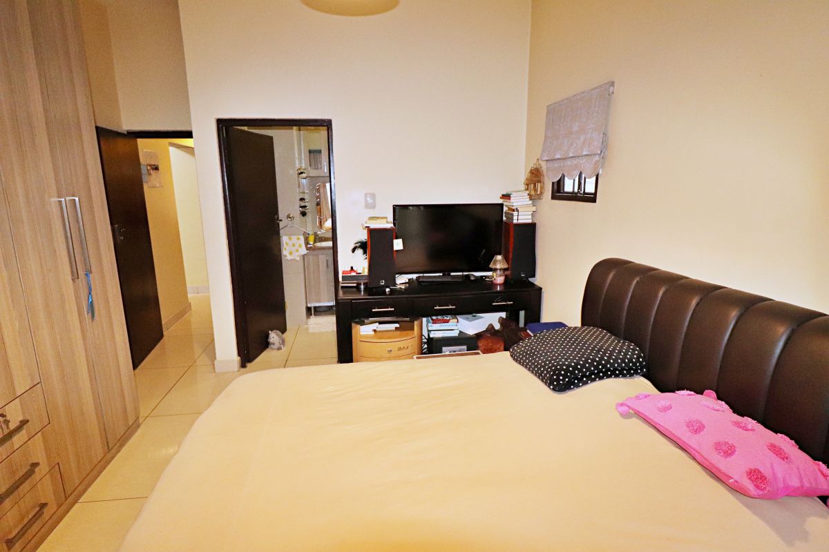 A bedroom featuring tiled flooring, a built-in wardrobe, and direct access to an en-suite bathroom.