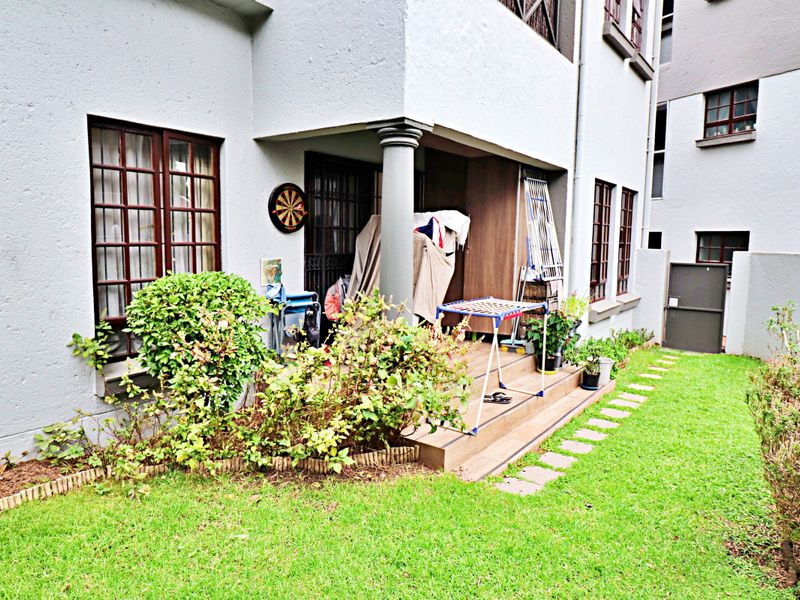 A ground-floor patio area featuring tiled flooring and a concrete support column, providing direct access to the adjacent garden space.