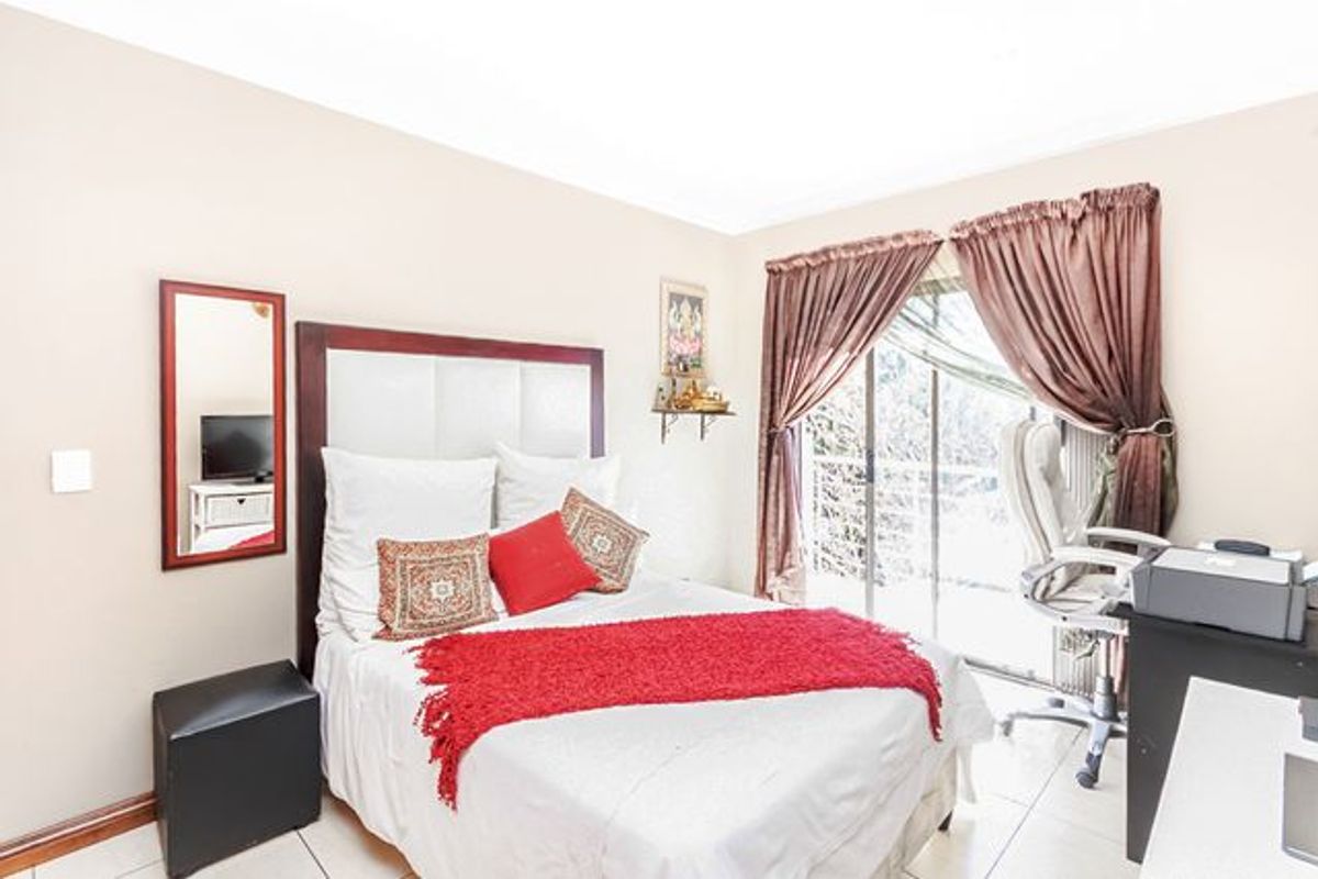 A bedroom featuring tiled flooring and a sliding glass door providing access to an outdoor area.