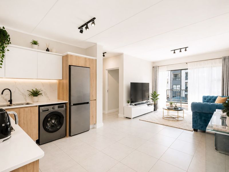 Modern open-plan living area featuring a sleek kitchen with integrated appliances, tiled floors, and direct access to a private balcony.