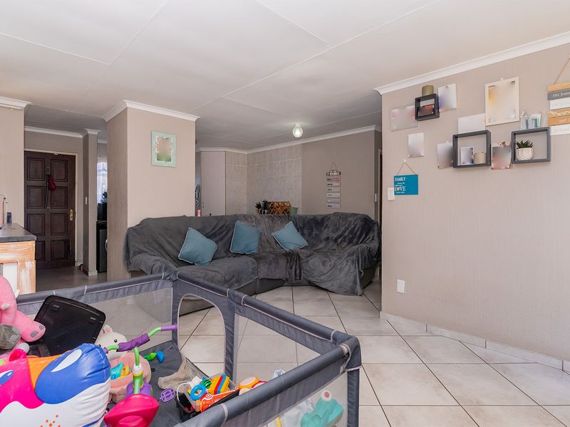 Open plan living area featuring tiled flooring and neutral wall finishes, providing a functional space with direct access to the home entrance.