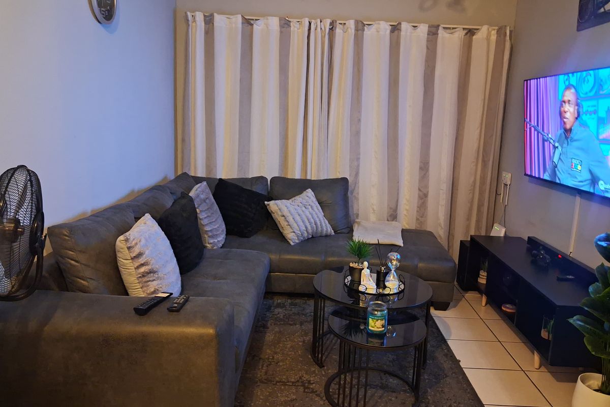 A functional living room featuring tiled flooring and neutral wall finishes, providing a comfortable space for relaxation.