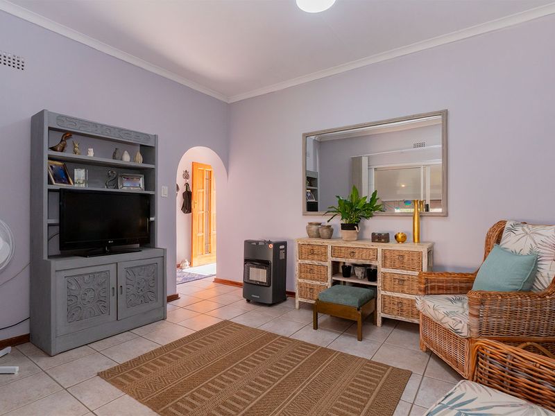 A living room featuring tiled flooring and a distinctive arched doorway leading to an adjacent space.