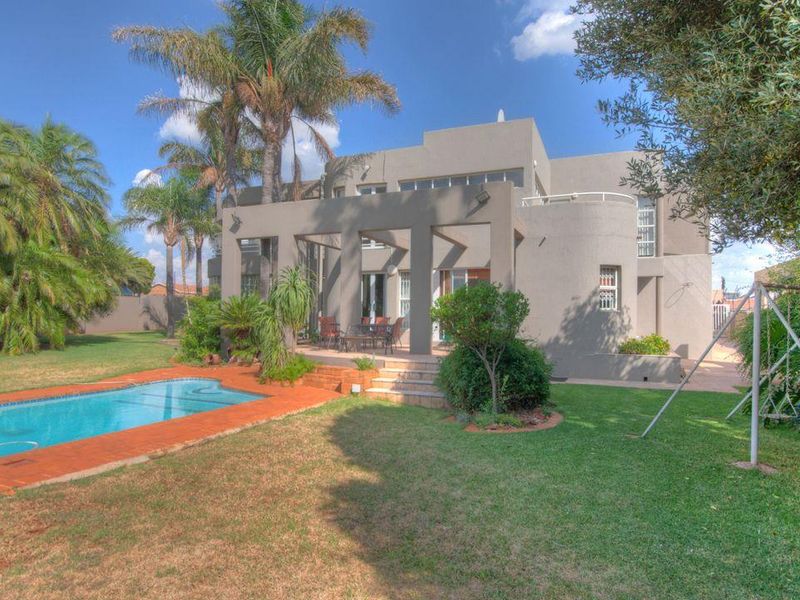 Rear view of the property featuring a spacious garden, a swimming pool, and a covered patio area perfect for outdoor entertaining.