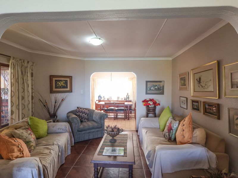 An open-plan living and dining area featuring tiled flooring and distinctive arched architectural transitions between the spaces.