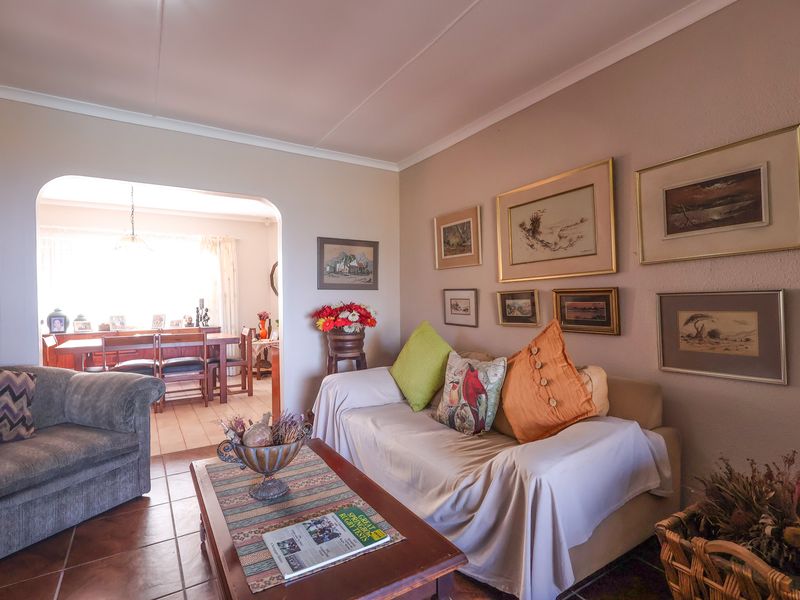 Open plan living and dining area featuring tiled flooring, coved ceilings, and a connecting archway between the two spaces.