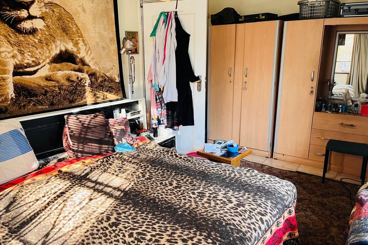 A bedroom featuring built-in wardrobes and carpeted flooring.
