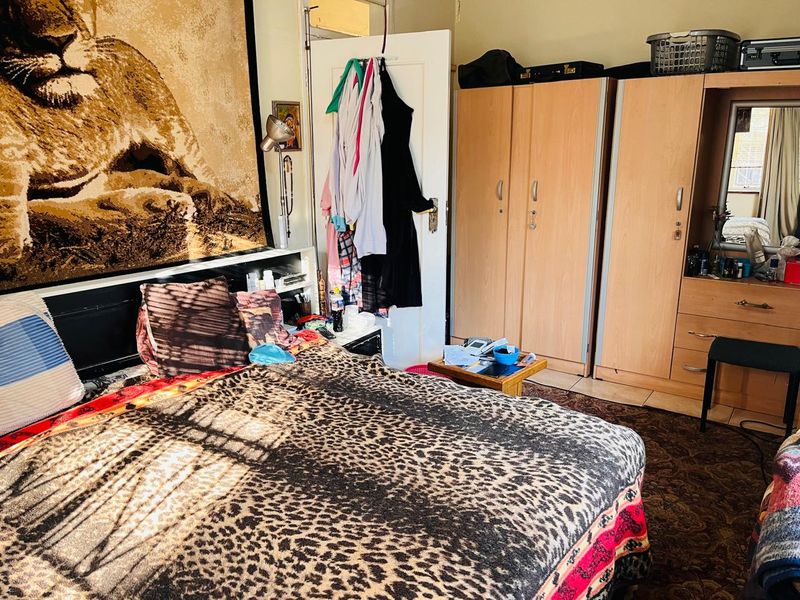 A bedroom featuring built-in wardrobes and carpeted flooring.