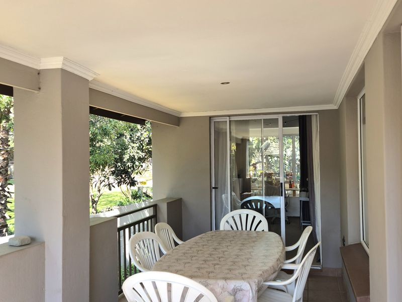A covered balcony featuring tiled flooring, recessed lighting, and a sliding glass door providing access to the interior living space.