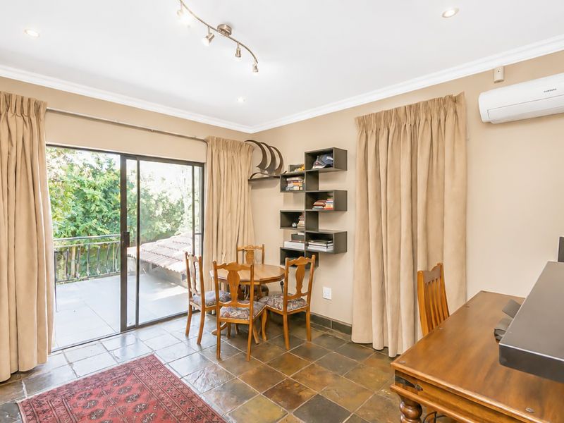 A living area featuring slate tile flooring, a split-system air conditioner, and a sliding glass door providing access to an outdoor patio.