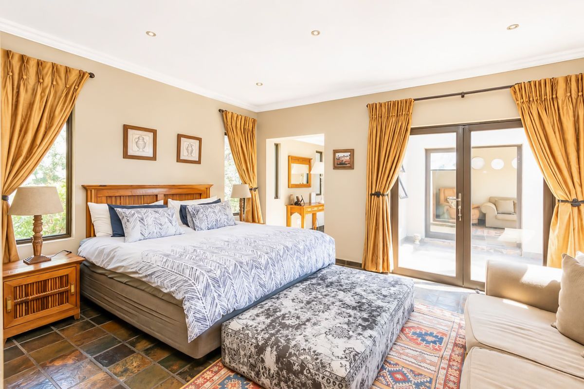 Spacious bedroom featuring slate tile flooring, recessed lighting, and direct access to an outdoor patio area through sliding glass doors.