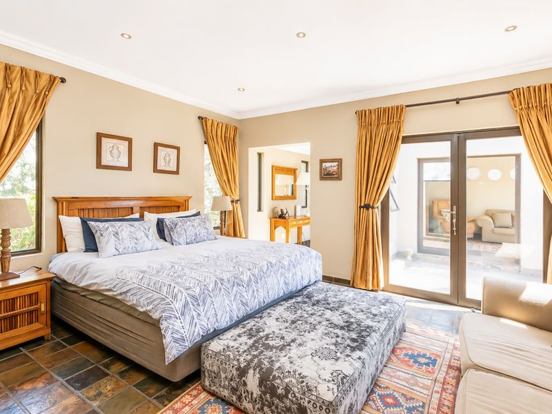 Spacious bedroom featuring slate tile flooring, recessed lighting, and direct access to an outdoor patio area through sliding glass doors.