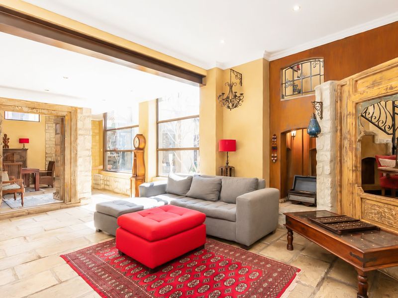 Spacious living area featuring natural stone flooring, large windows for ample light, and unique architectural stone wall accents.