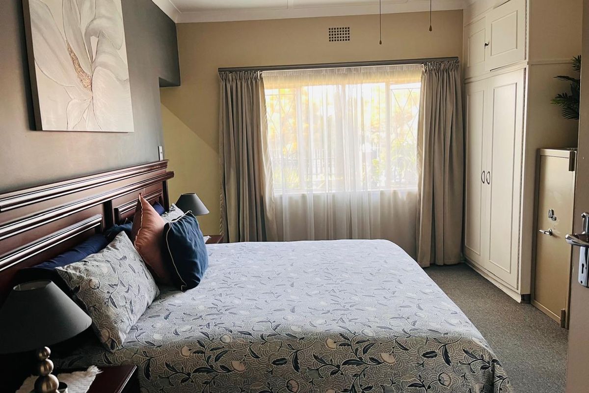 A well-maintained bedroom featuring built-in cupboards, carpeted flooring, recessed lighting, and a ceiling fan, offering a comfortable and functional living space.