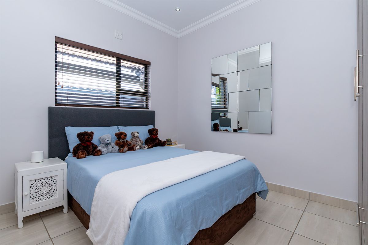 A well-maintained bedroom featuring tiled flooring, recessed downlighting, venetian blinds, and built-in cupboard storage.