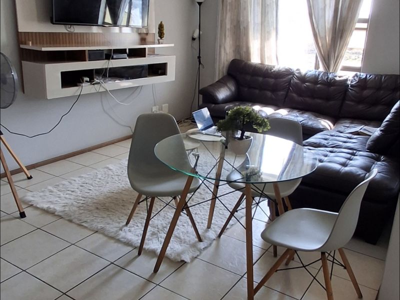 A living room featuring tiled flooring and a built-in media console unit, providing a functional space for relaxation and entertainment.