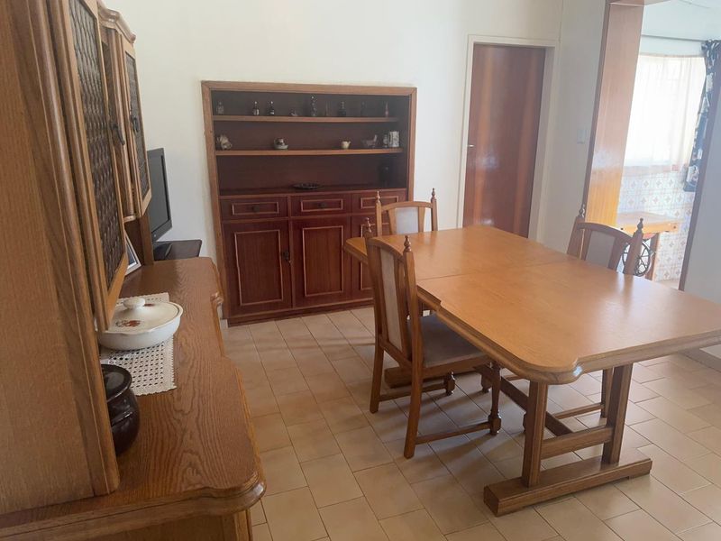 A dining room featuring ceramic tile flooring and built-in wooden cabinetry, offering a functional space for meals.