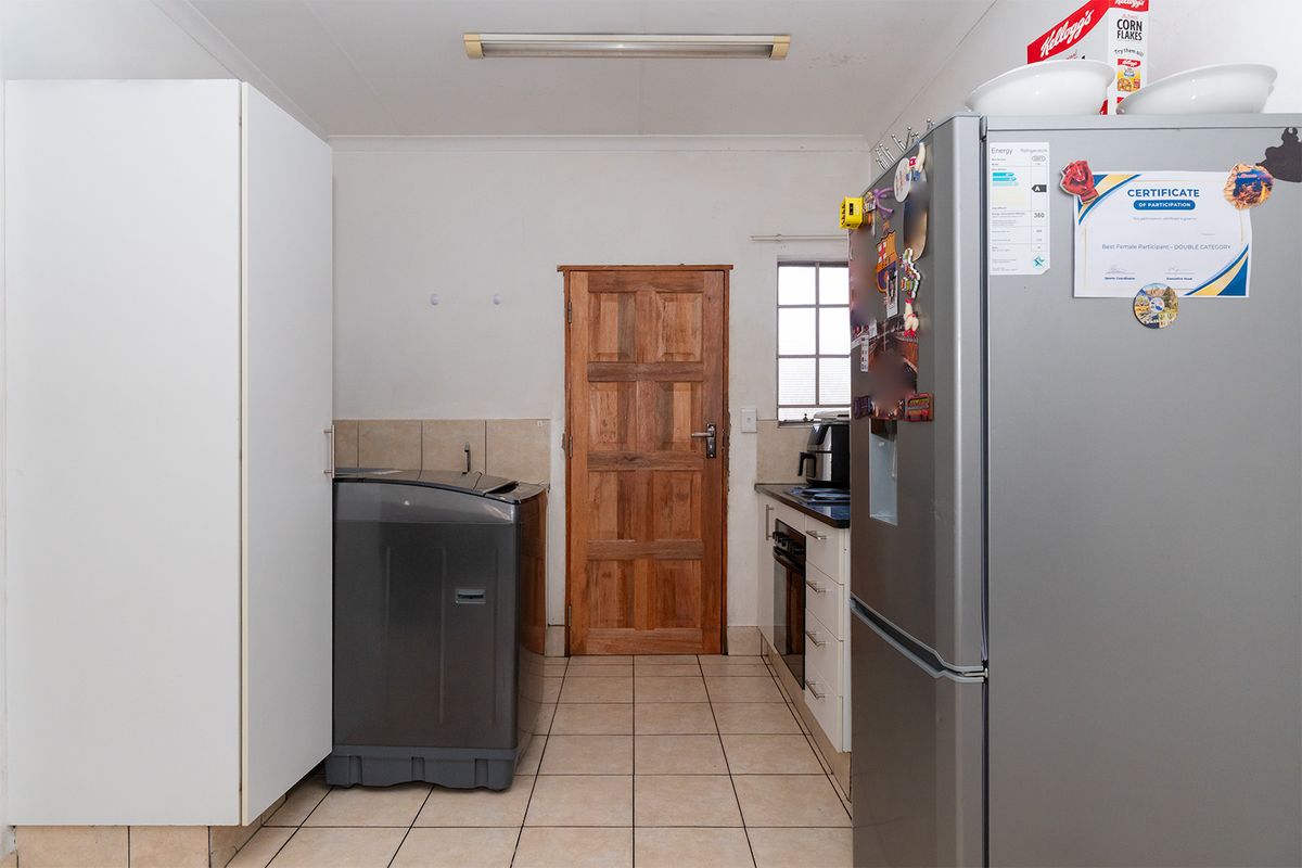 A functional kitchen area featuring tiled flooring, built-in cabinetry, and integrated cooking appliances, providing a practical space for daily meal preparation.