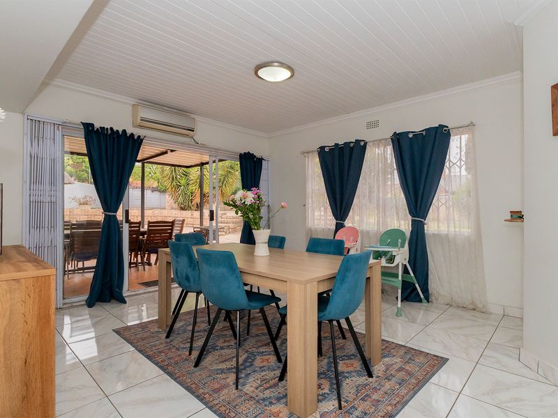 Bright dining area featuring tiled flooring, tongue and groove ceiling, and sliding glass doors providing seamless access to the outdoor patio space.