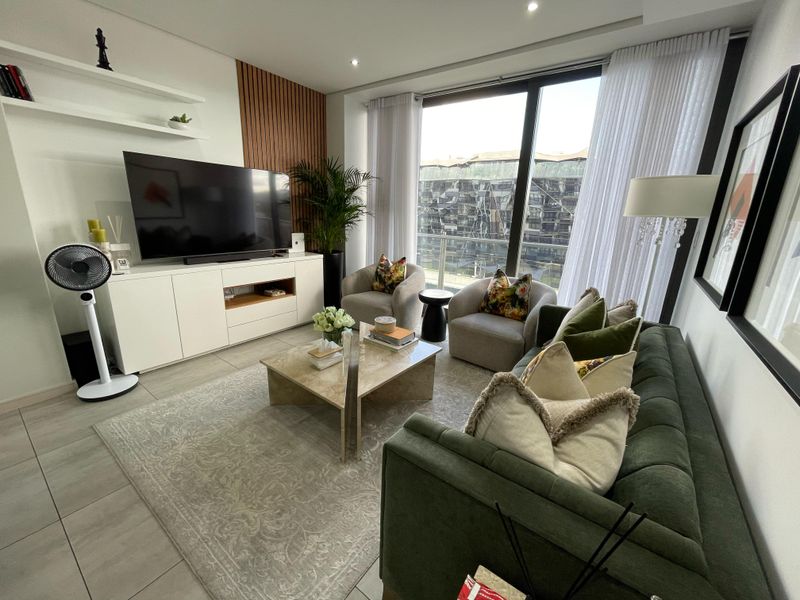 Modern living room featuring tiled floors, recessed lighting, a timber slat feature wall, and large sliding glass doors leading to a balcony.
