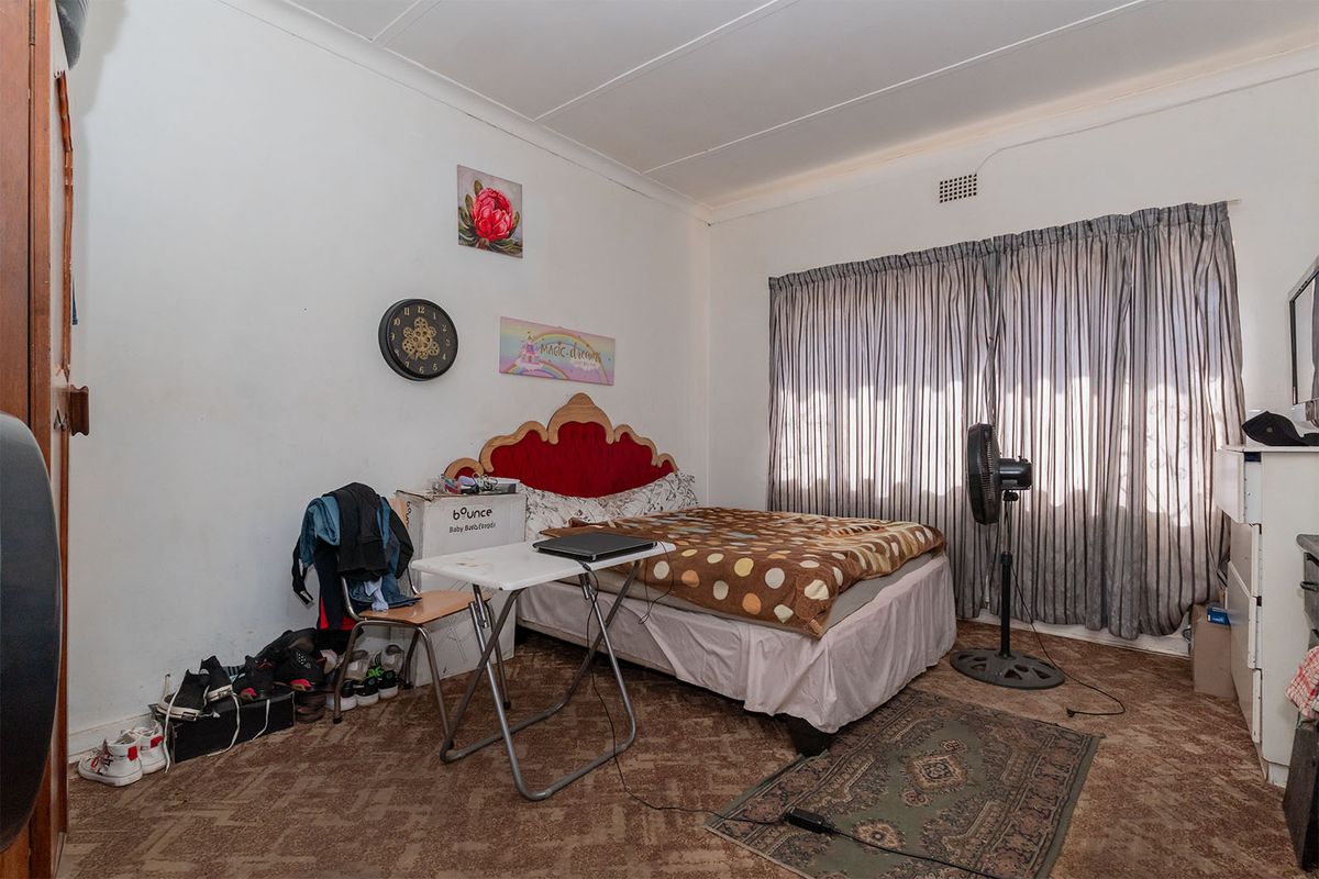 A bedroom featuring carpet flooring and window curtains, requiring cosmetic updates to improve the overall aesthetic and condition of the space.