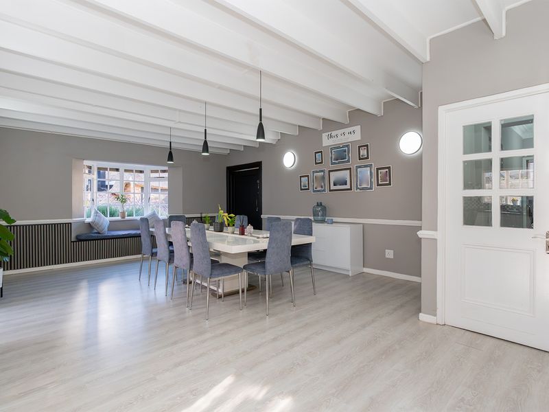 Spacious dining room featuring exposed beam ceilings, wainscoting, and a charming built-in window seat with bay window views.