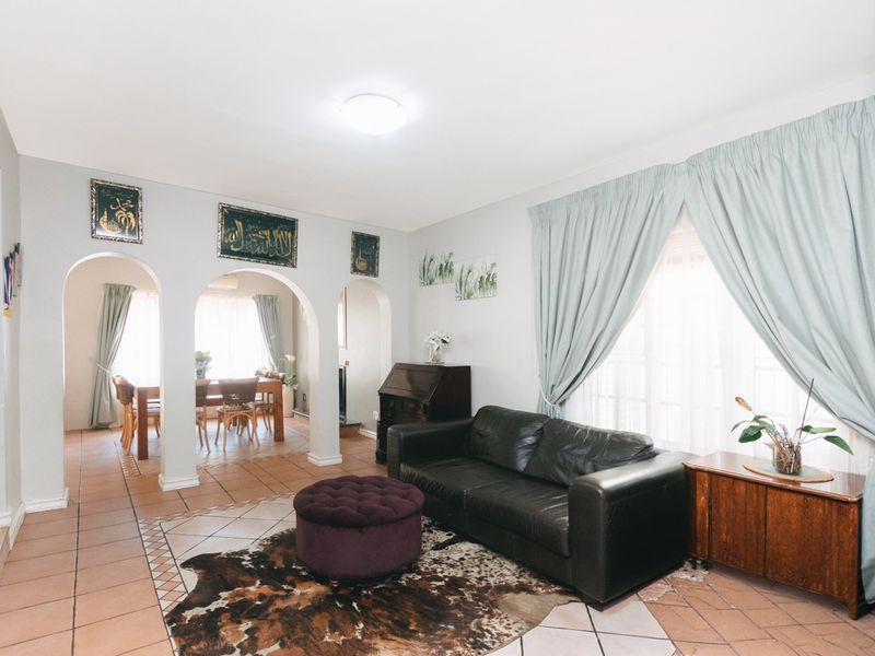 Open plan living and dining area featuring distinctive arched architectural details and tiled flooring throughout.