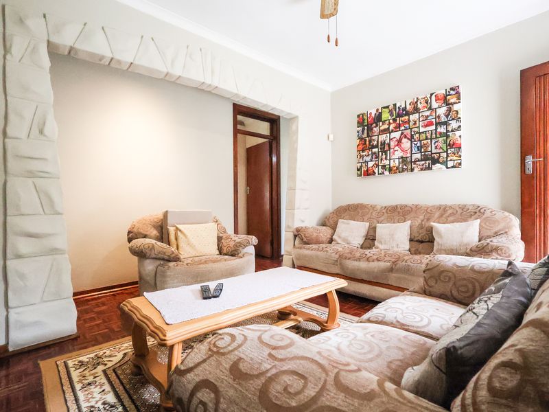 A living room featuring classic parquet flooring and a distinctive decorative stone archway, providing a traditional foundation for interior updates.