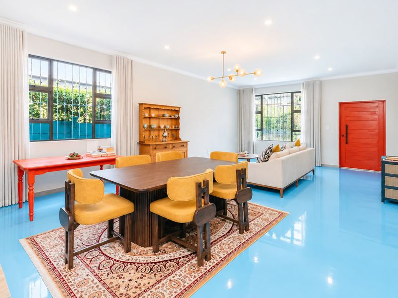 Spacious open-plan living and dining area featuring high-gloss epoxy flooring, recessed lighting, and large windows with security bars.