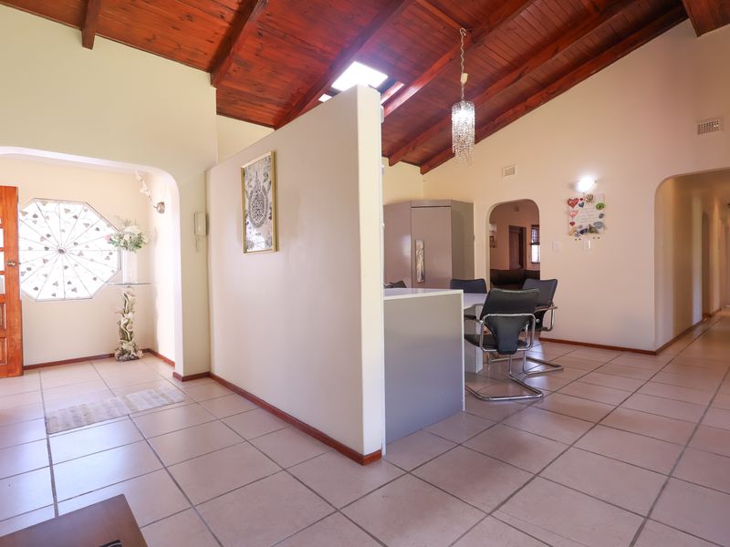Open plan living area featuring high exposed timber raked ceilings, a skylight, tiled flooring, and a central partition wall creating distinct zones.